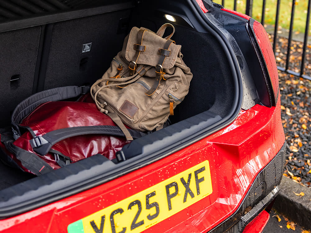 Open boot of a red MINI showing a backpack and duffel bag inside.