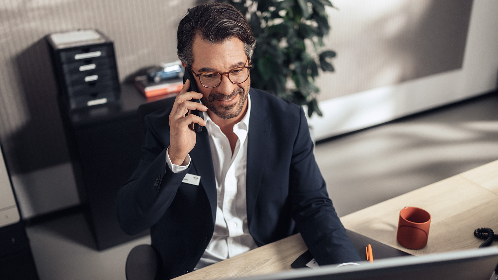 MINI agent sitting at the desk and speaking on mobile