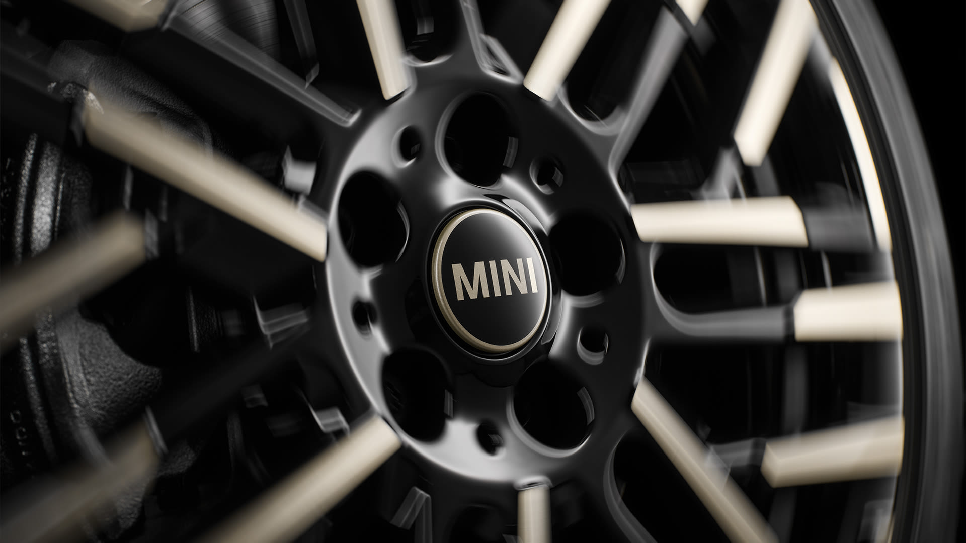 Close-up of a black and silver MINI car alloy wheel with the MINI logo in the center.
