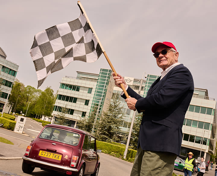 Elderly man with chessboard pattern flag calling the end of race