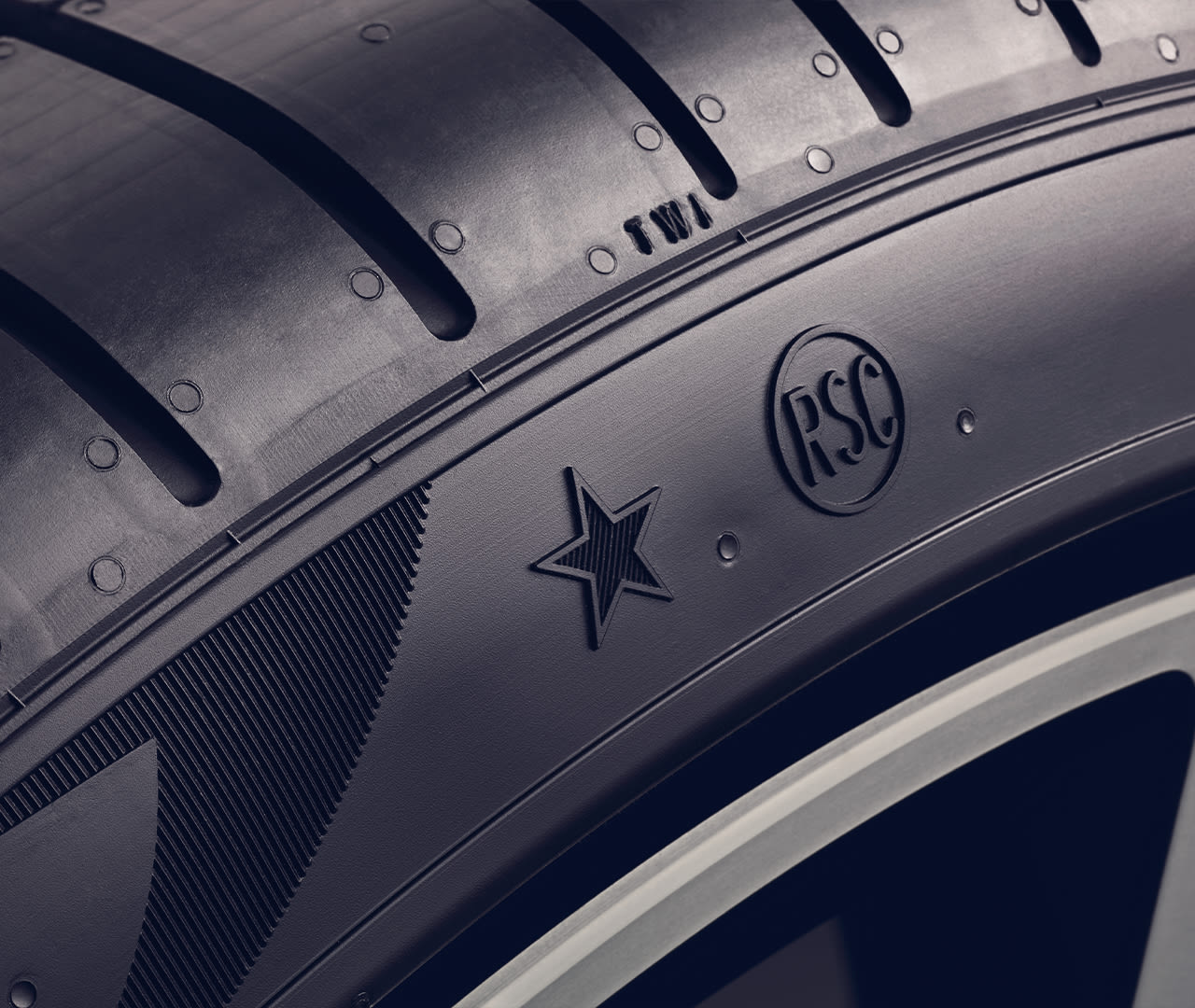 Close-up of a MINI run flat car tire showing tread patterns and sidewall markings including a star symbol and 'RSC' lettering.