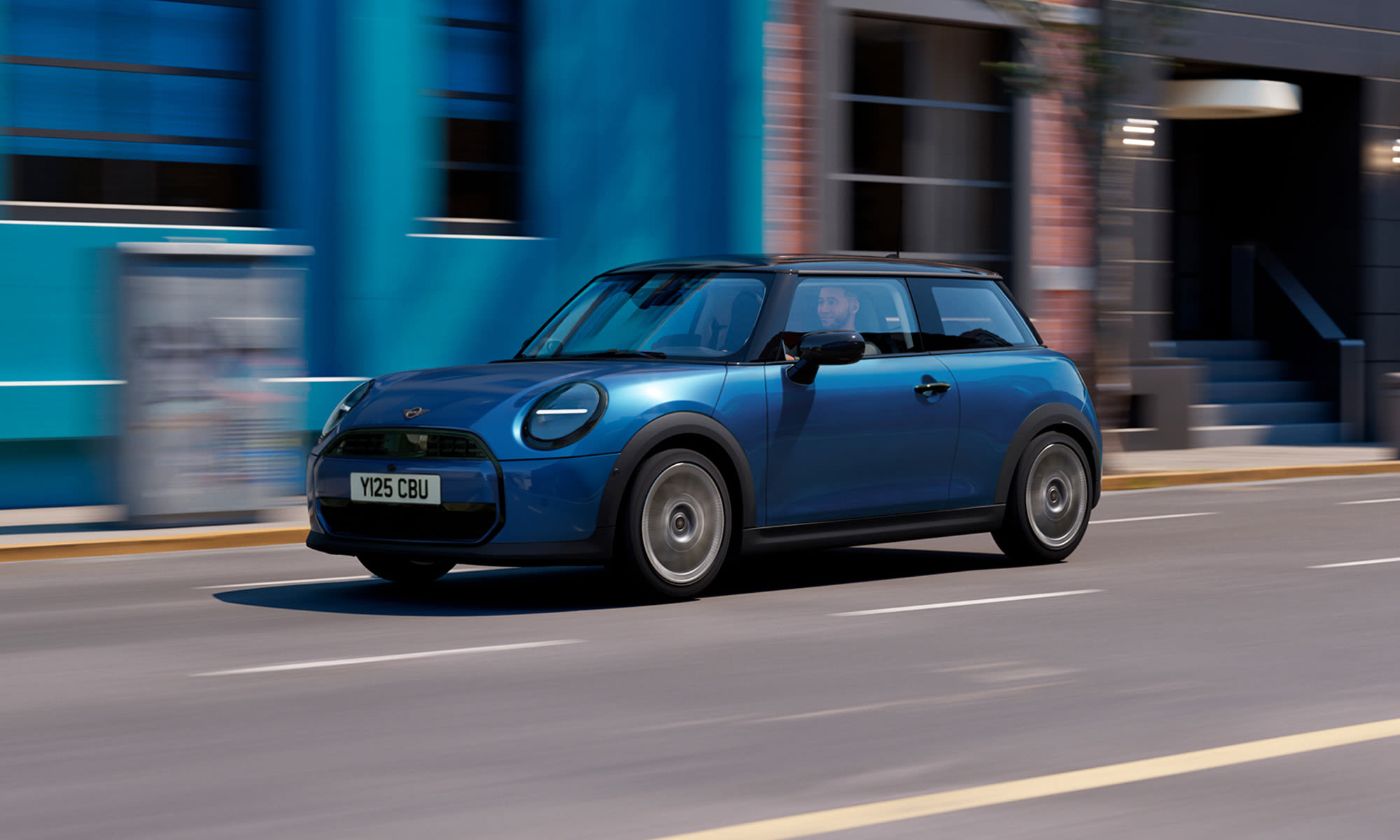 Blue MINI Cooper driving along a city street.