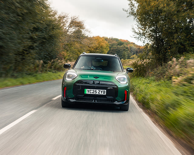 Front view of green MINI JCW Electric driving on a country road
