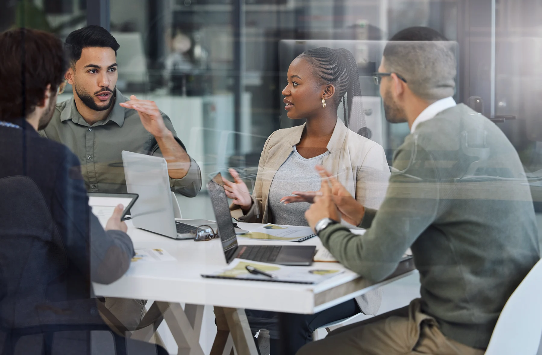 Men and woman sitting at a desk talking