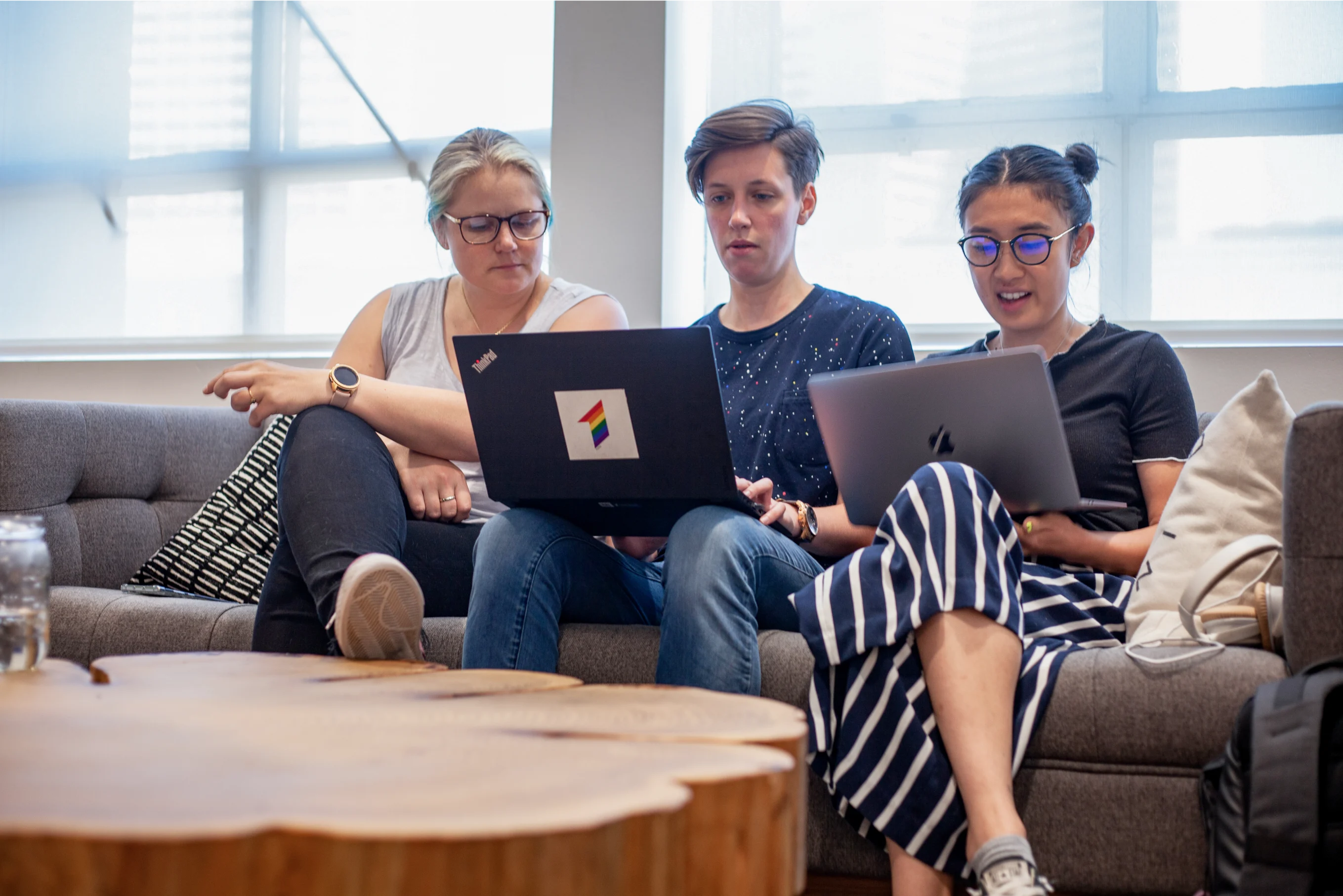 Roofstock employees look at computers on sofa