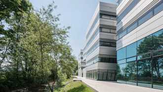 Doppelmayr Seilbahnen Firmenzentrale, ein mehrstöckiges Firmengebäude mit weißer Verkleidung und langen Glasfronten sorgt für ein modernes, zeitloses Erscheinungsbild