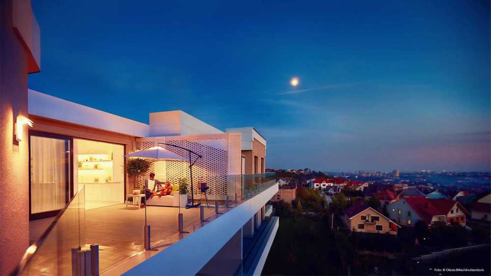 Gebäude mit großem Balkon, gläsernen Zaun und Außenbeleuchtung sorgt für idyllische und entspannende Abende im Freien.