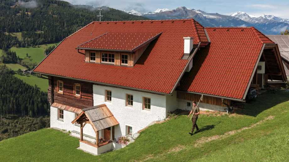 Familienhaus mit Bergpanorama und Dachsteinen mit Aerlox Class Ultra in der Farbe rubinrot sowie weißer Fassade