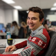 Gabriel Laroche in Christmas sweater, smiling in an office.