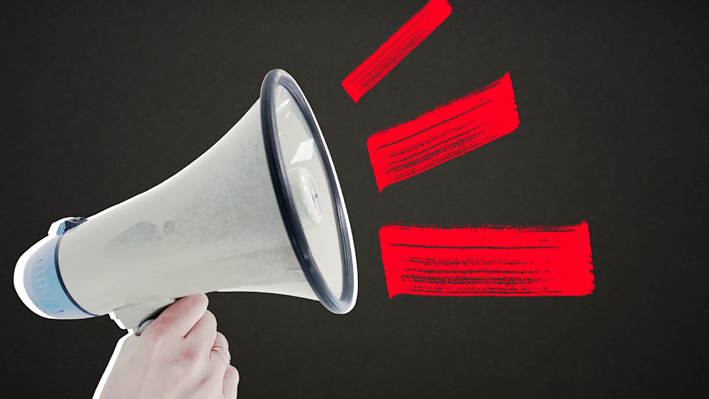 A white megaphone against a black background, with line suggesting noise