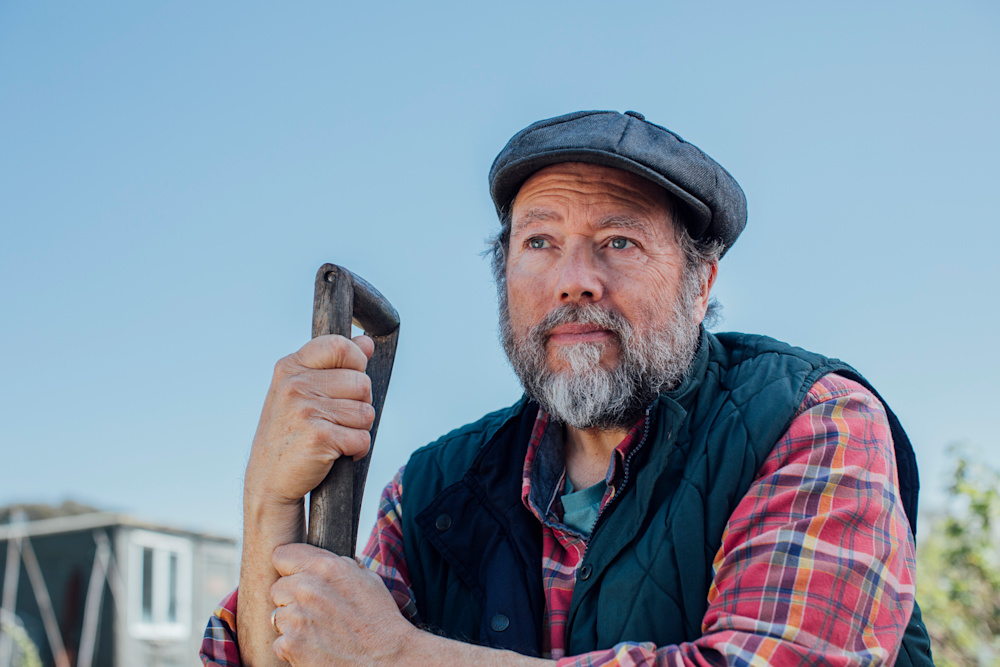 Don gardening, leaning on a spade