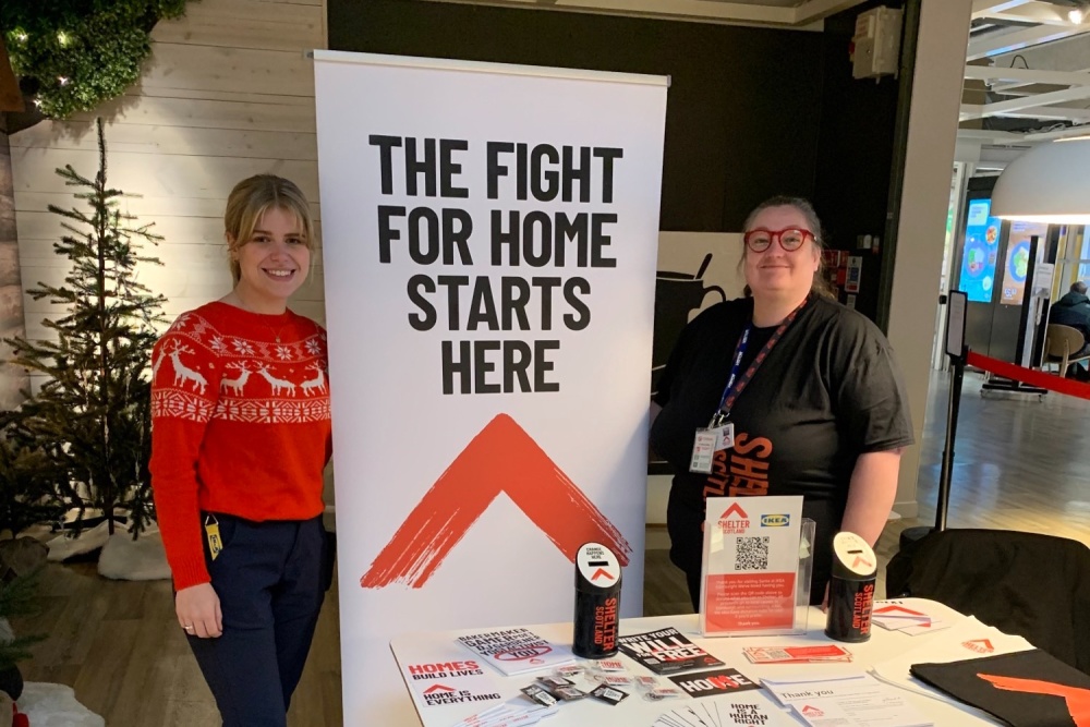 2 women stand next to Shelter Scotland banner in an Ikea shop