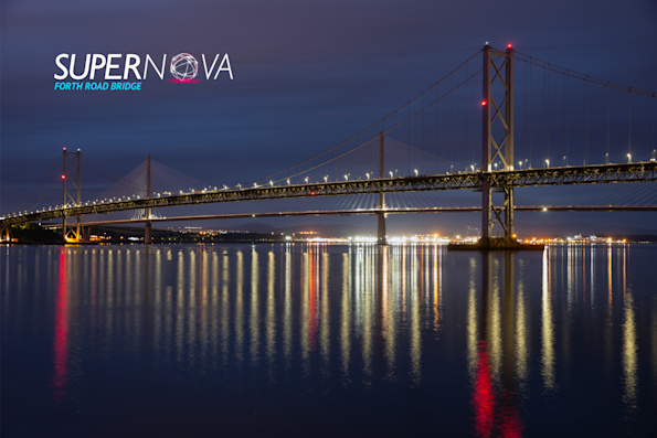 Forth Road Bridge lit up at night with lights reflecting on the water. Text reads 'Supernova Forth Road Bridge'.