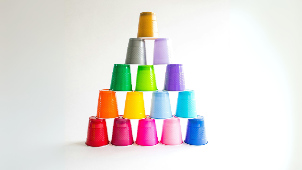 A selection of stacking cups in various colours, arranged in a pyramid