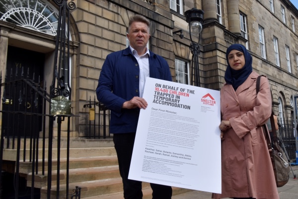 Shelter Scotland campaigners holding a letter to the First Minister. The opening line reads 'On behalf of the 10,480 children trapped in temporary accommodation.'