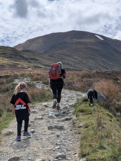 Faye, her mum and her dog are walking up the path to climb the Munro. Fay is wearing a Shelter Scotland 'Home is everything' T-shirt.