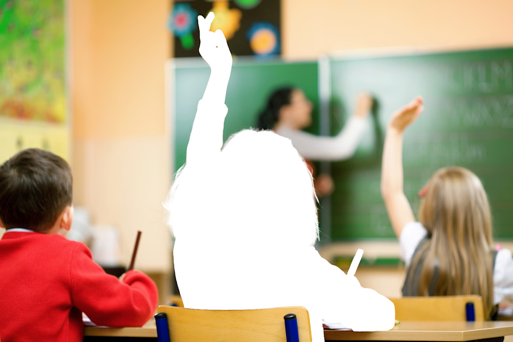 Children in a classroom facing towards their teacher and raising their hands but child in middle is a silhouette only