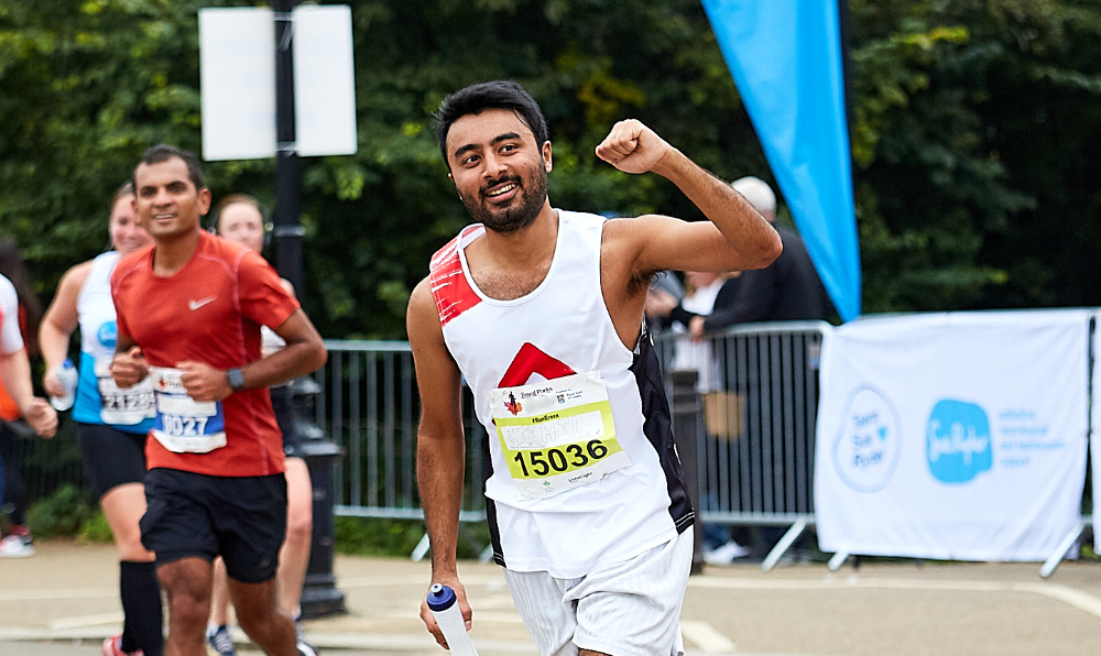 A race runner wearing a Shelter vest in Berlin triumphantly raising his arm