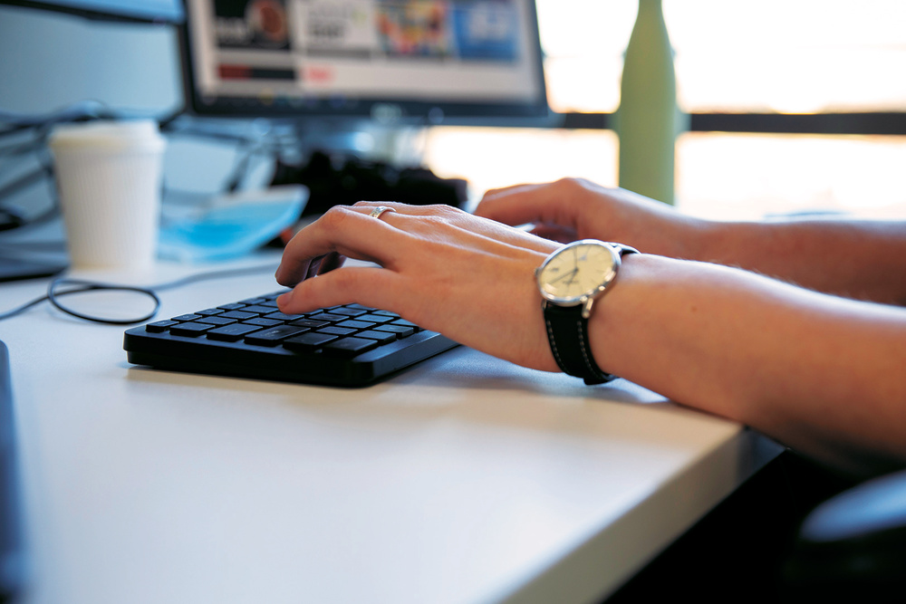 Picture of helpline advisor's hand typing on a keyboard 
