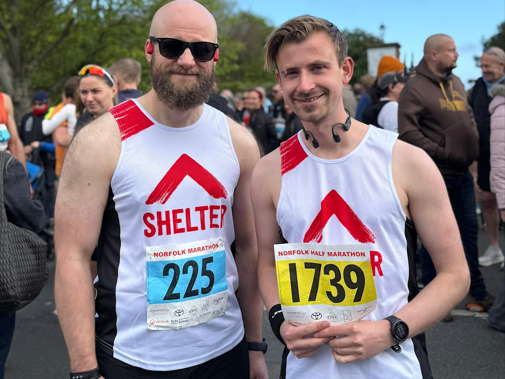 Two Sandringham Half Marathon runners smile at the camera, wearing their running numbers 225 and 1739.