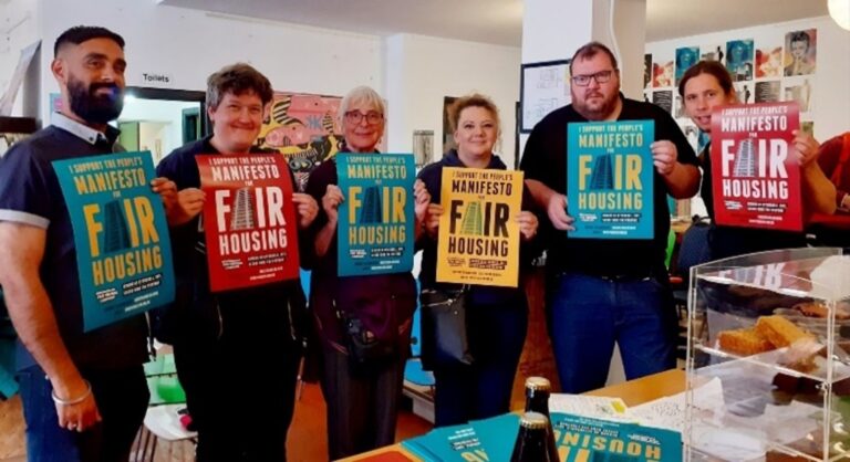 A group of campaigners holding colourful Birmingham Fair Housing Campaign posters