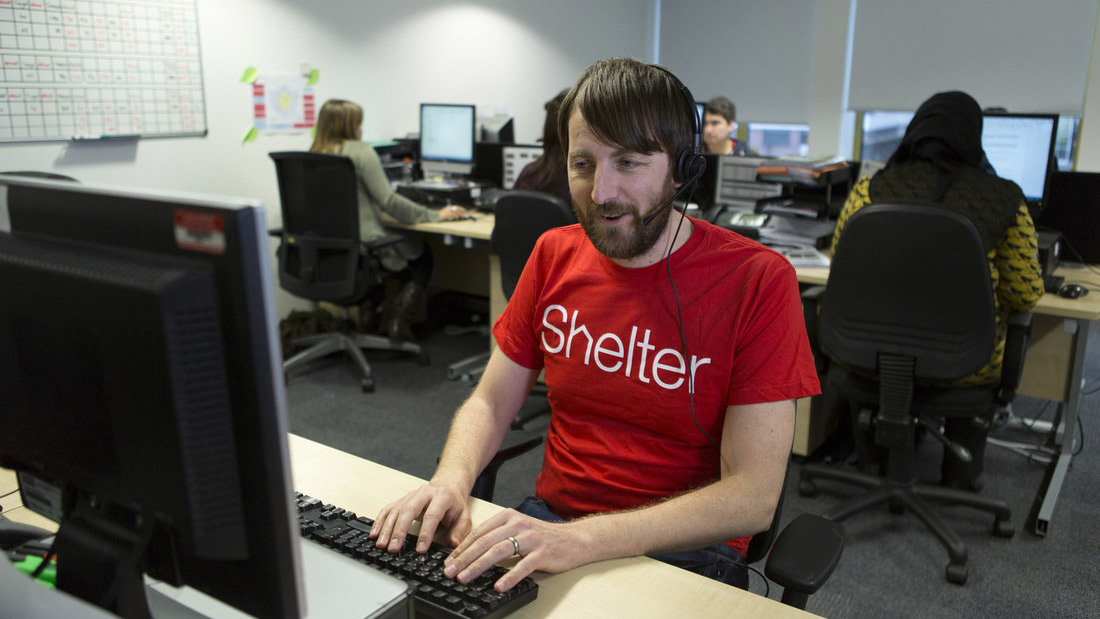 A man with a headset offers advice on the Shelter helpline