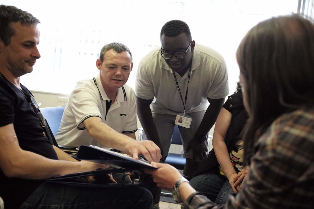 A group of people are seen working with Shelter to share their stories