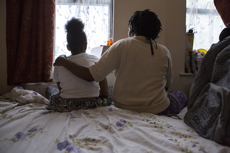 A woman and a child sitting on a bed