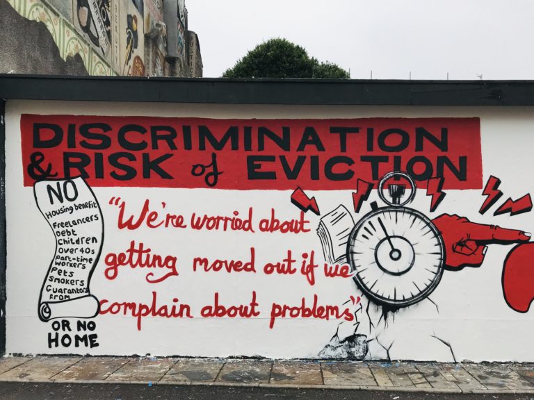 Mural with a big title 'Discrimination & Risk of Eviction' with the quote 'We're worried about getting moved out if we complain about problems'. It is illustrated with a long list of conditions and a ticking clock.