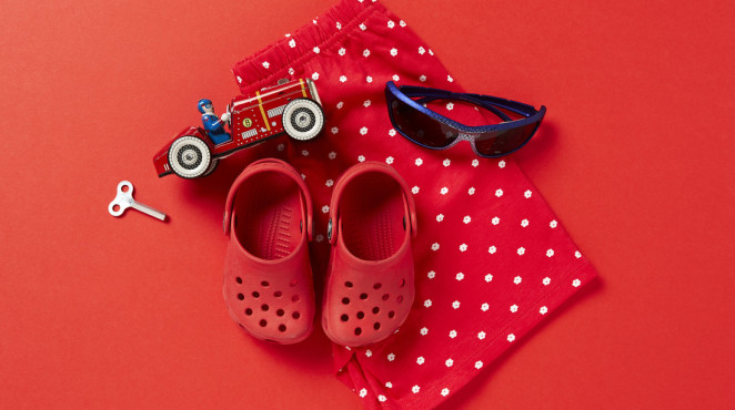 Flat lay of shoes, trousers, sunglasses and a toy car