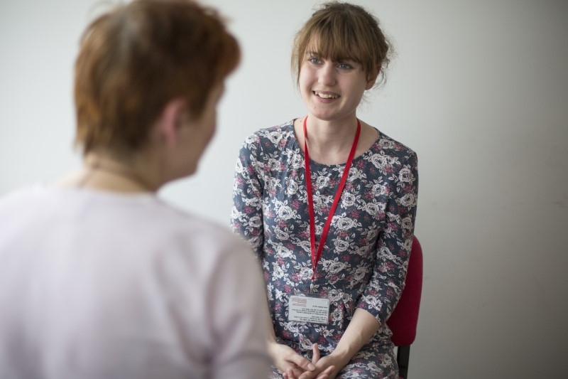 A Shelter adviser, smiling and talking to a client