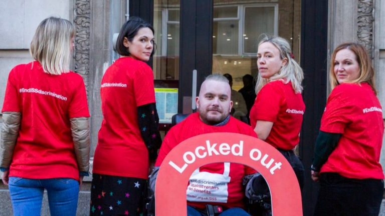 A group of campaigners wearing red Shelter T-shirts with the slogan 'End DSS discrimination'