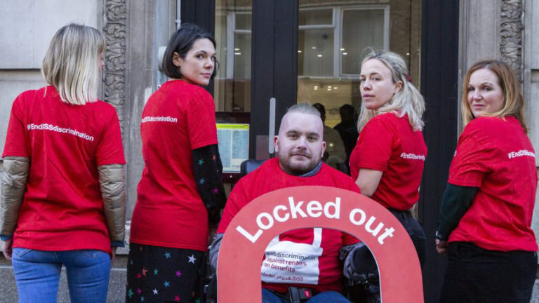 A group of campaigners wearing red Shelter T-shirts with the slogan 'End DSS discrimination'