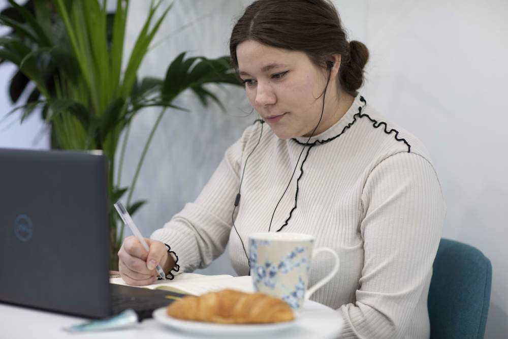 Webinars for individuals image of girl at computer with earphones and breakfast