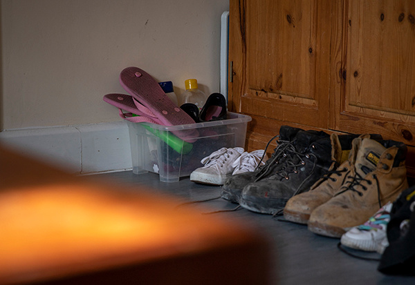 A line of shoes by a wardrobe in a temporary accommodation room