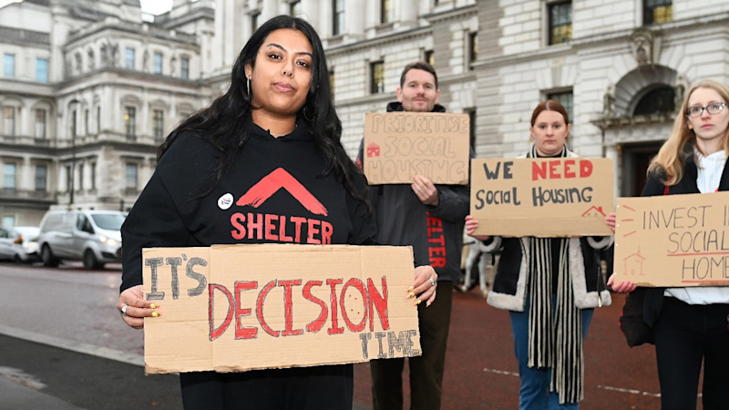 A Shelter campaigner holding a placard reading 'It's decision time'