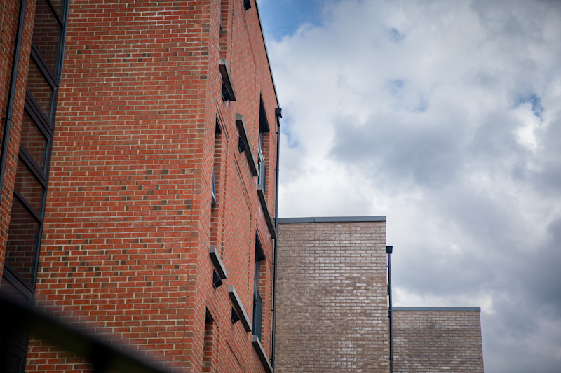 An orange brick side view of a social flat in Manchester