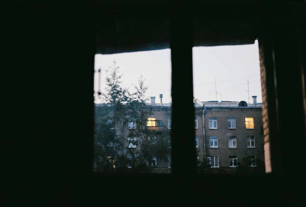 View of a building out of a window from a dark interior.