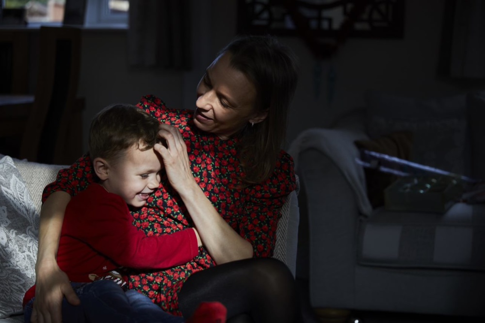 A woman cuddling her toddler.