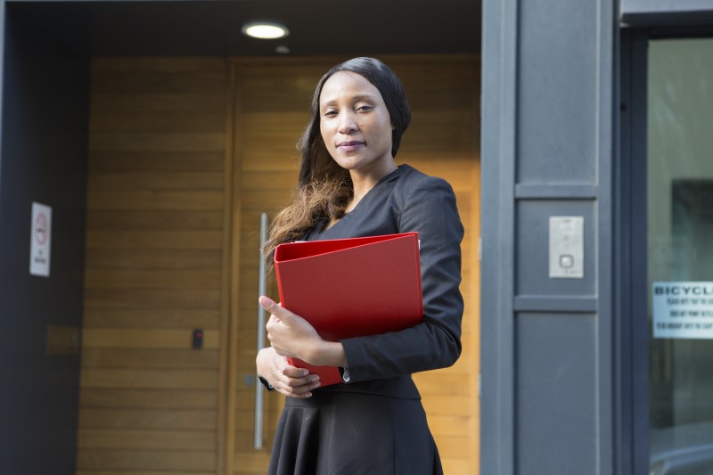 A Shelter legal adviser, holding a folder, with a serious look on her face