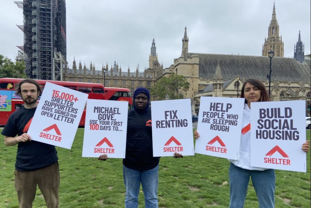 Shelter campaigners hold placards in front of Westminster.