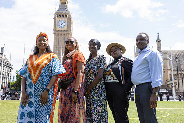 A group of peer researchers standing outside the Houses of Parliament in Westminster.