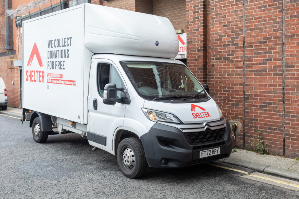 A Shelter van delivering items to one of our furniture shops. The van displays the Shelter logo and text 'We collect donations for free'