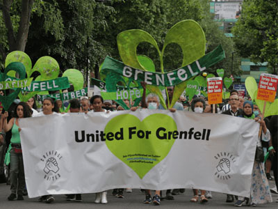 Silent walk for Grenfell. People march in green clothes, green heart signs and a banner that says 'United For Grenfell'. Photo credit: Steve Eason