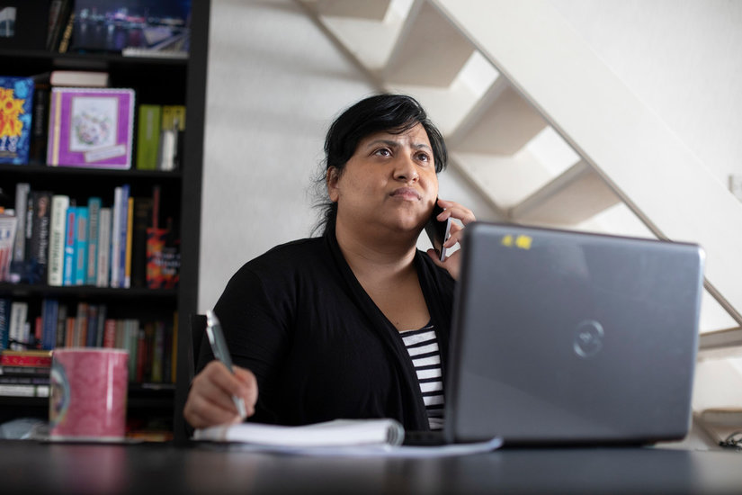 Woman using her computer, on the telephone