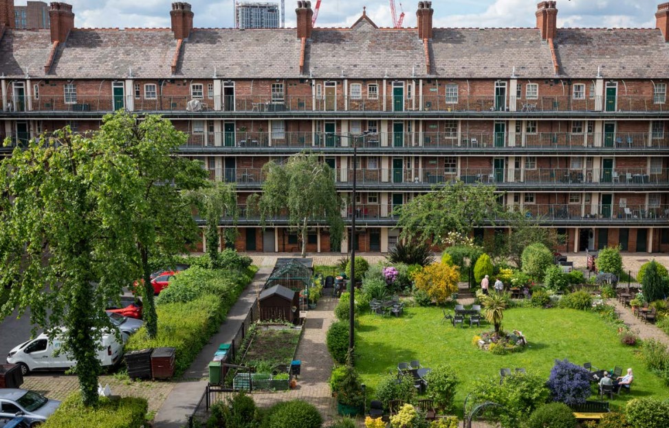 Social housing block with communal square. Tenants can be seen enjoying the sunny day.