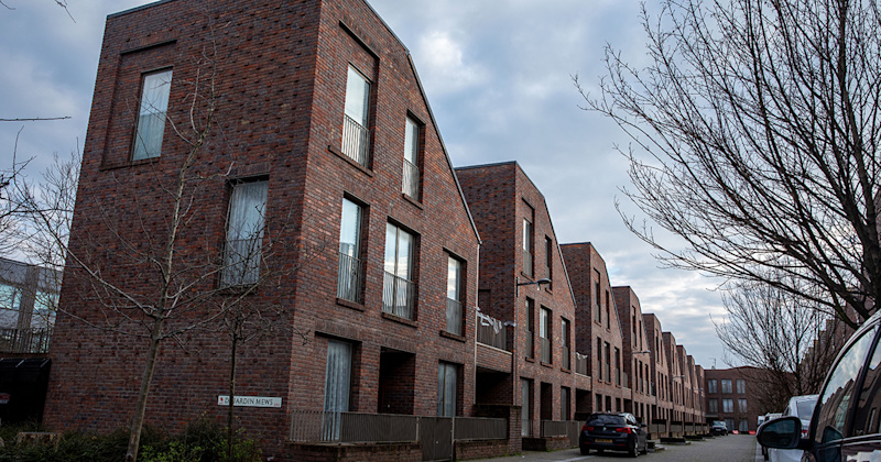 A row of red brick social houses on a London street