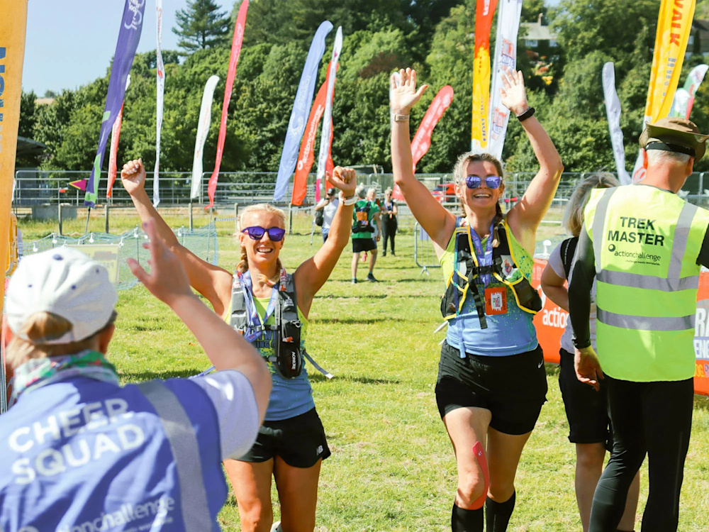 Two walkers raise their arms in celebration as they come to the Ultra Challenge finish line.