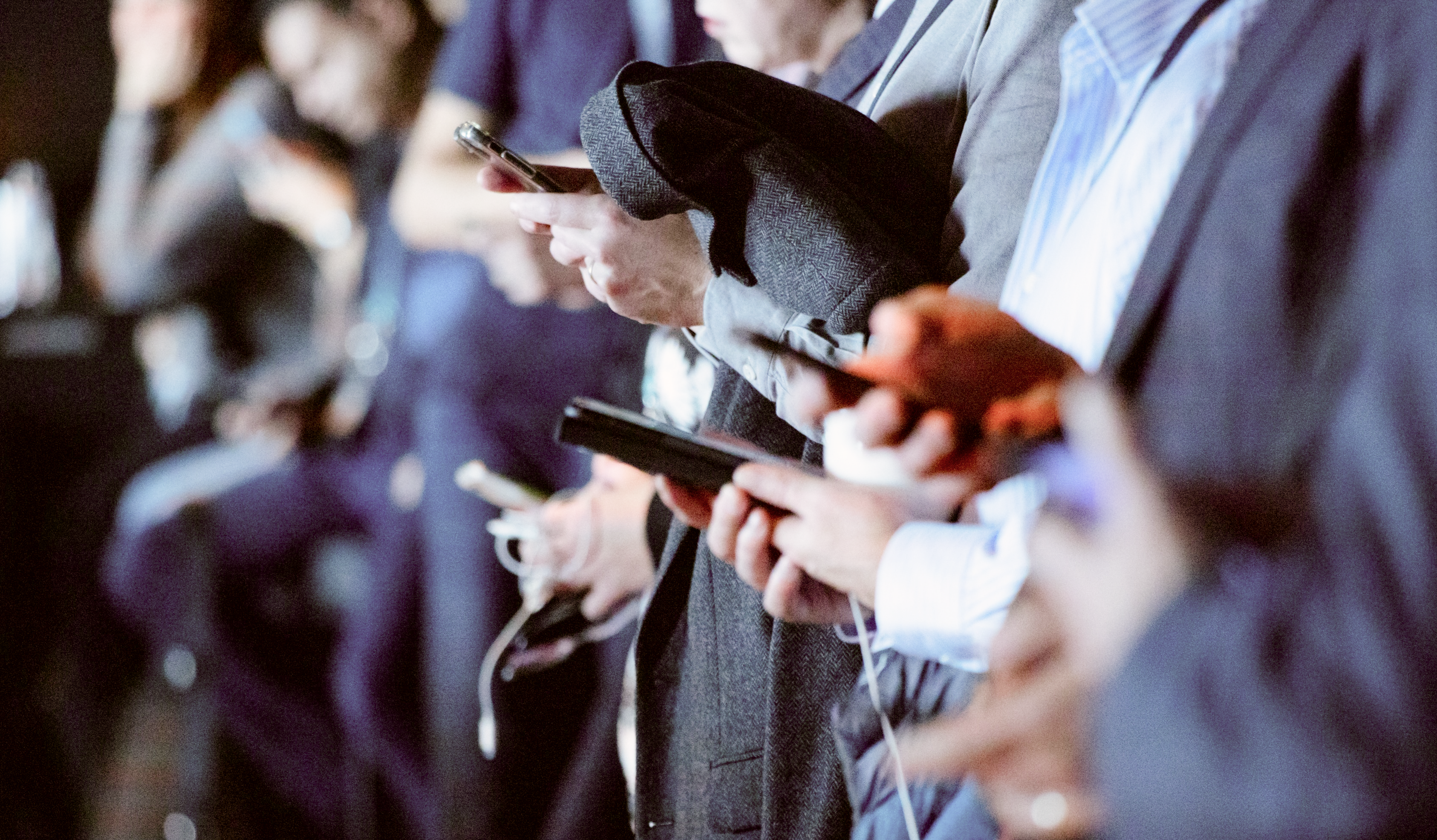 A close up profile of multiple people browsing smartphones.