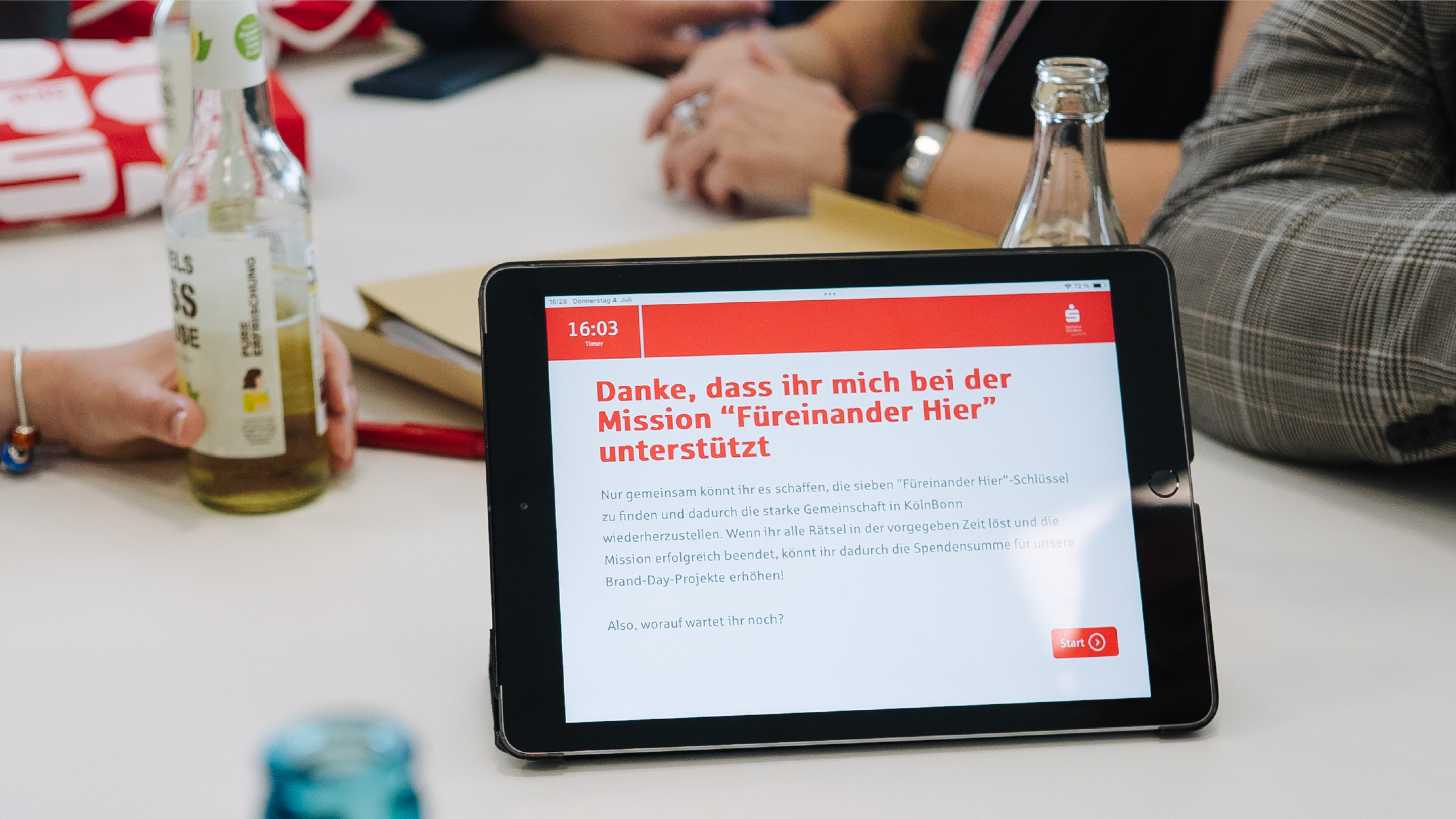 Tablet with headline: Danke, dass ihr mich bei der Mission "Füreinander Hier" - Escape Game